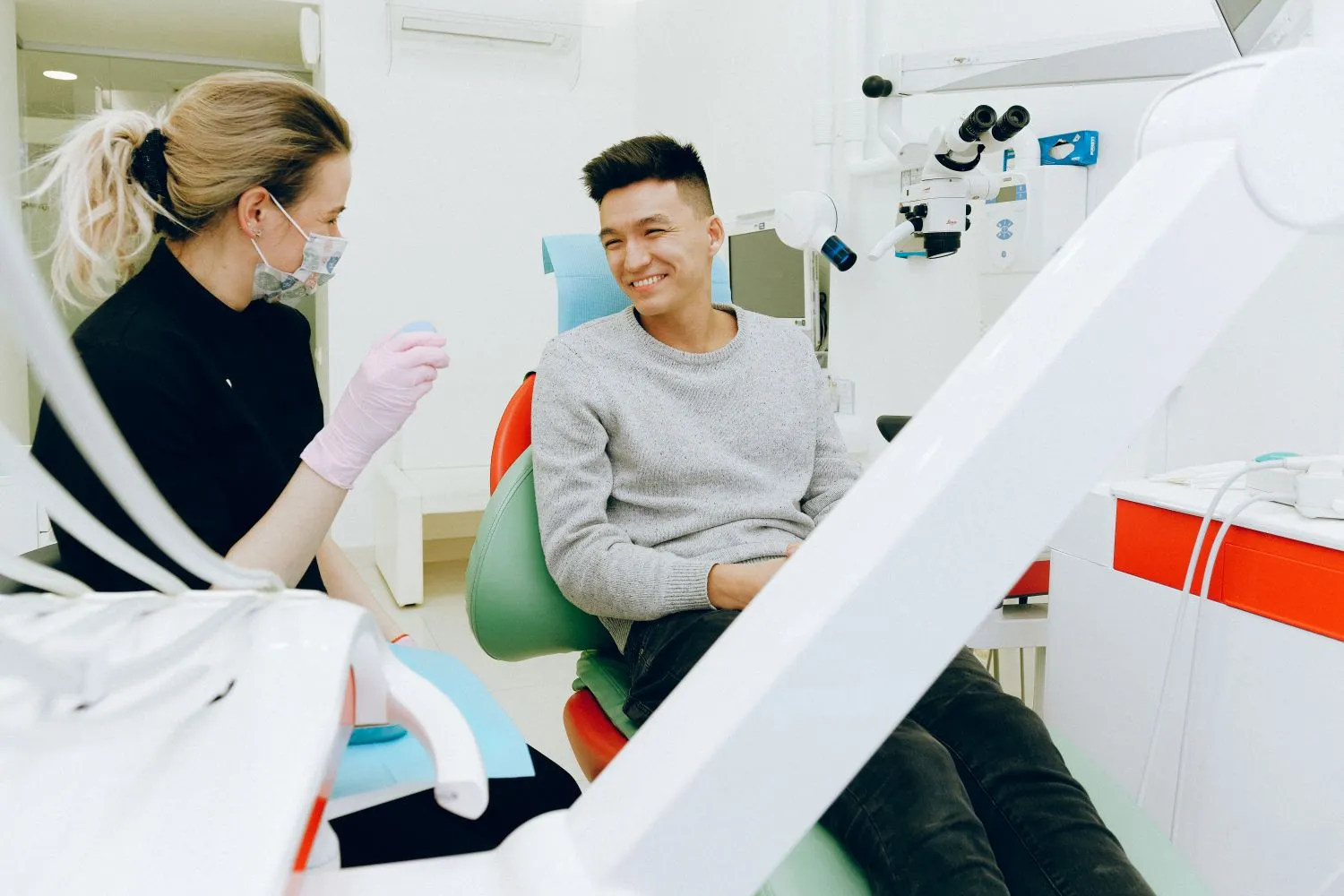 A dental team greeting a patient in the treatment room