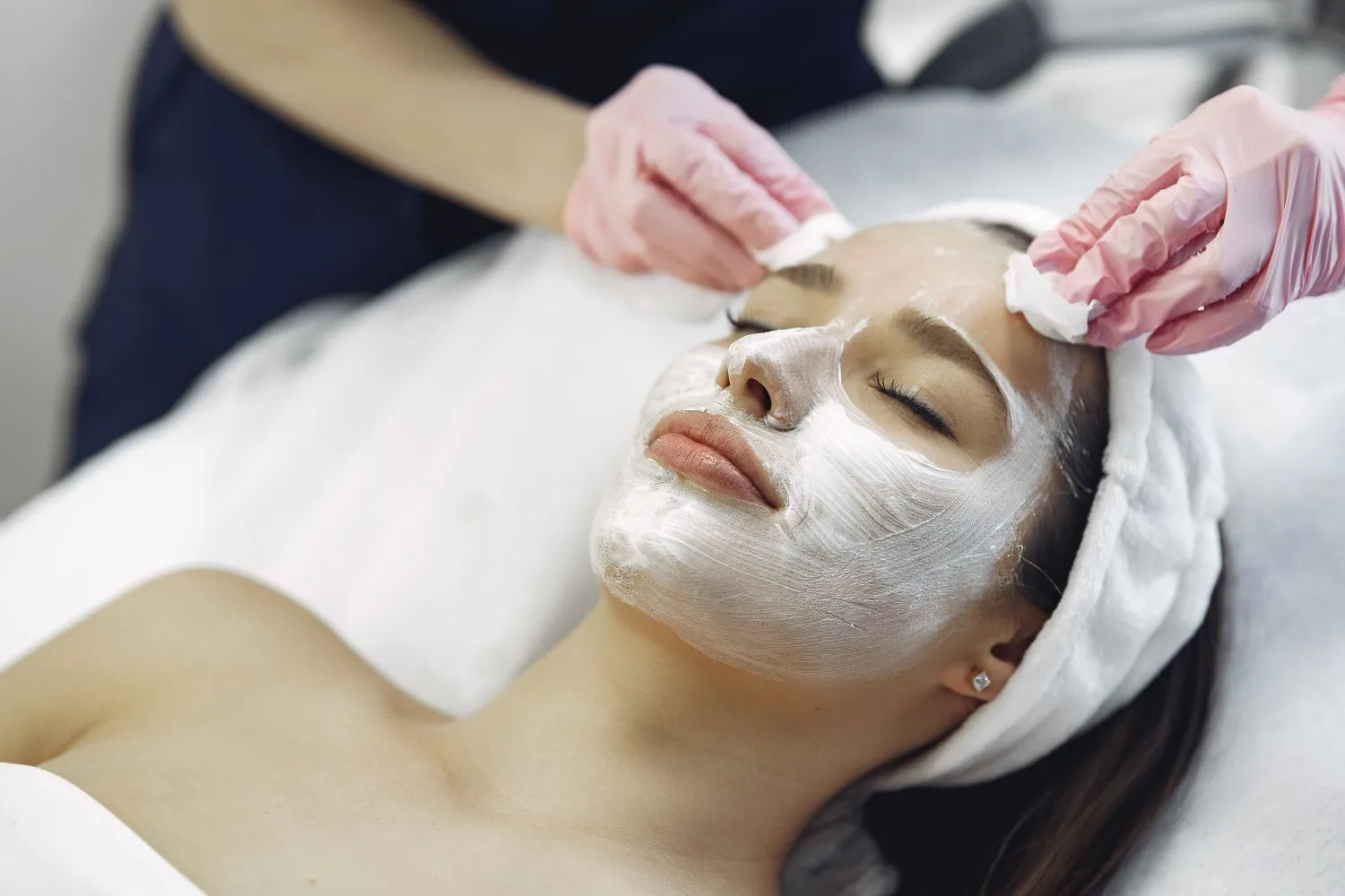 An esthetician performing a facial treatment on a client